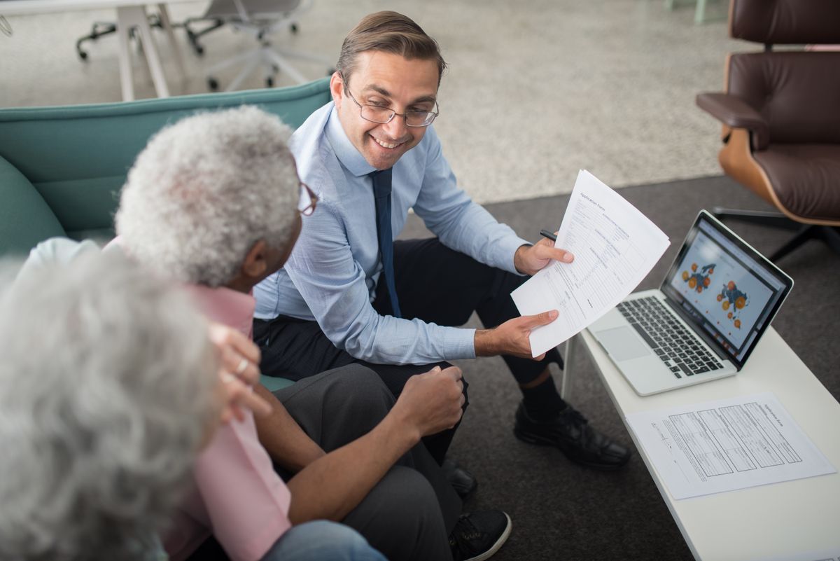 Asesor mostrando a un cliente la documentación de un fondo de inversión