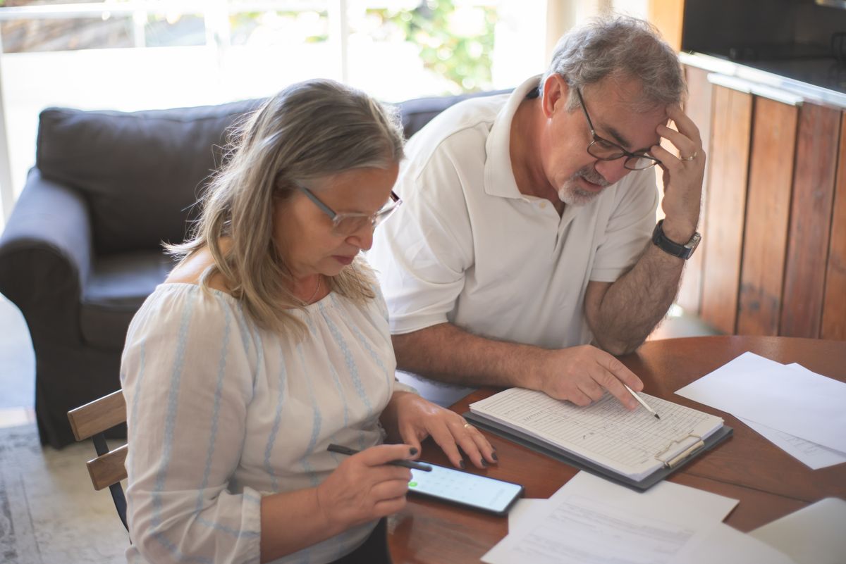 Pareja de mayores revisando en casa los documentos de su ahorro para la jubilación